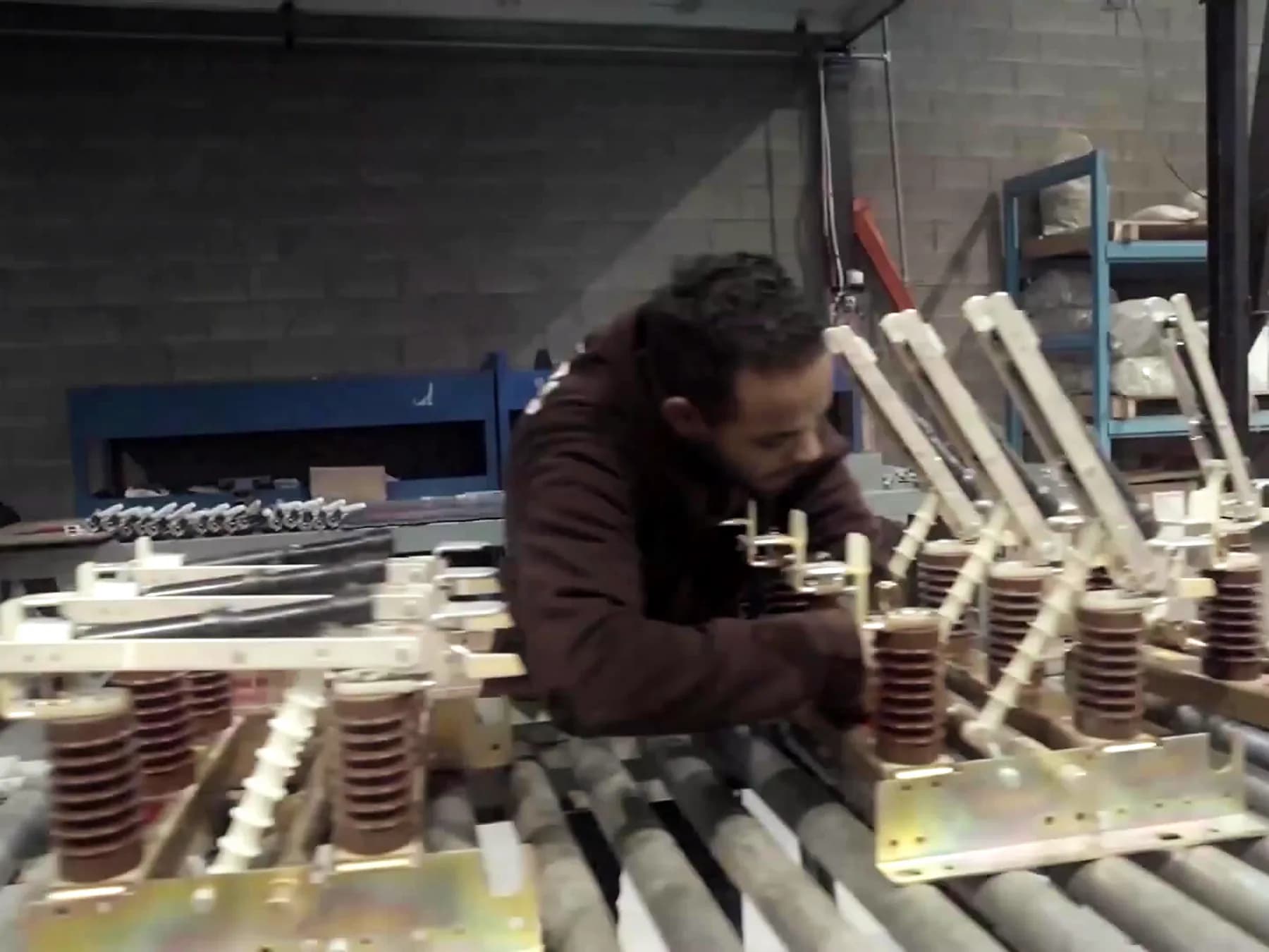 A worker handling medium voltage insulators and contacts